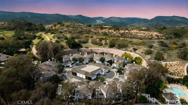 aerial view at dusk featuring a mountain view and a residential view