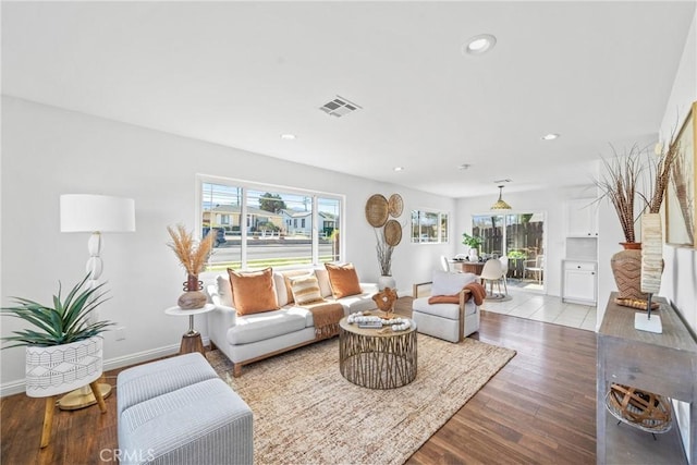 living room with plenty of natural light, wood finished floors, visible vents, and recessed lighting