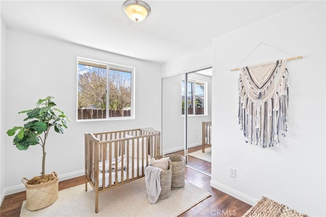 bedroom featuring a closet, baseboards, and wood finished floors