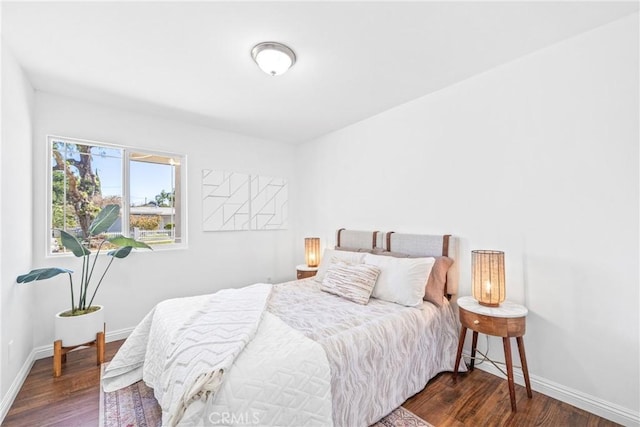 bedroom featuring baseboards and dark wood finished floors