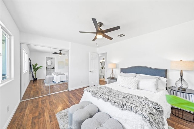 bedroom featuring baseboards, visible vents, a ceiling fan, wood finished floors, and a closet