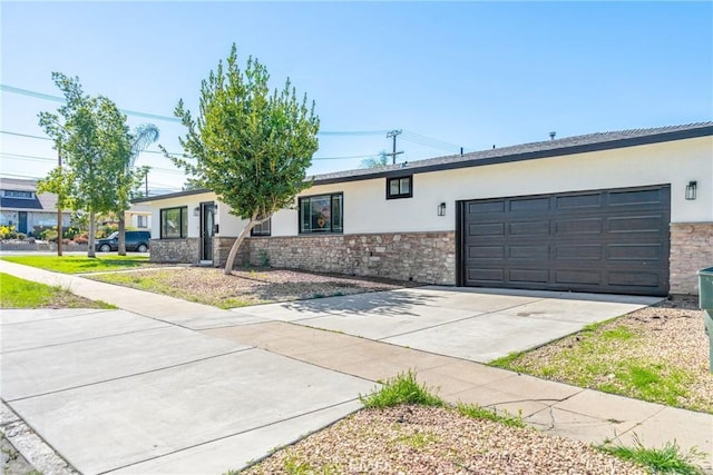 ranch-style home featuring a garage, concrete driveway, stone siding, and stucco siding