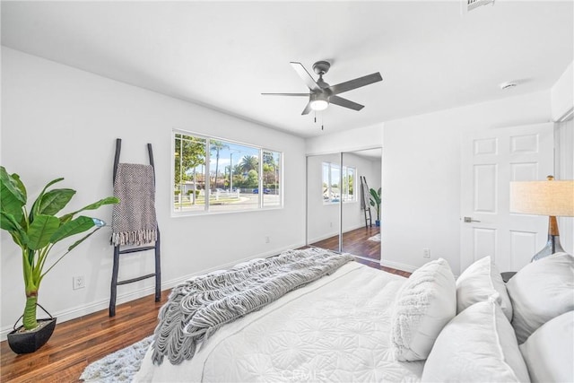 bedroom with a closet, ceiling fan, baseboards, and wood finished floors