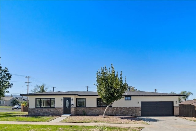 ranch-style home with concrete driveway, stone siding, an attached garage, and stucco siding