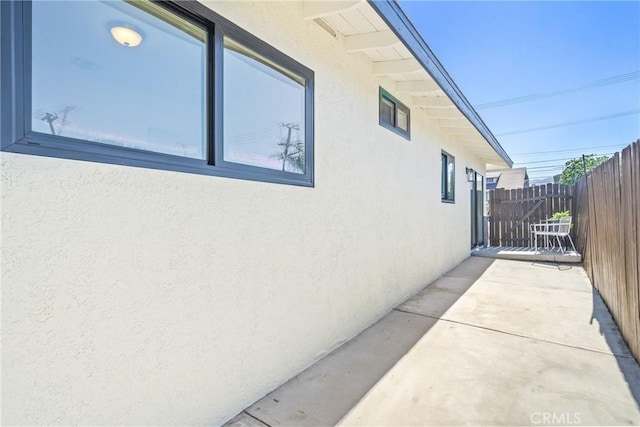 view of home's exterior featuring fence, a patio, and stucco siding