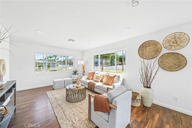 living area with visible vents, baseboards, and wood finished floors