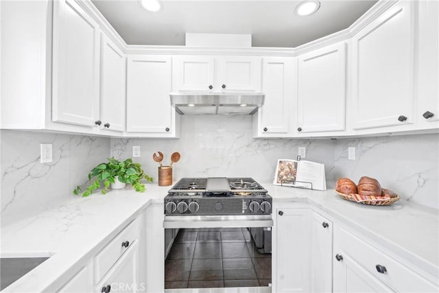 kitchen with stainless steel gas range oven, white cabinets, and under cabinet range hood