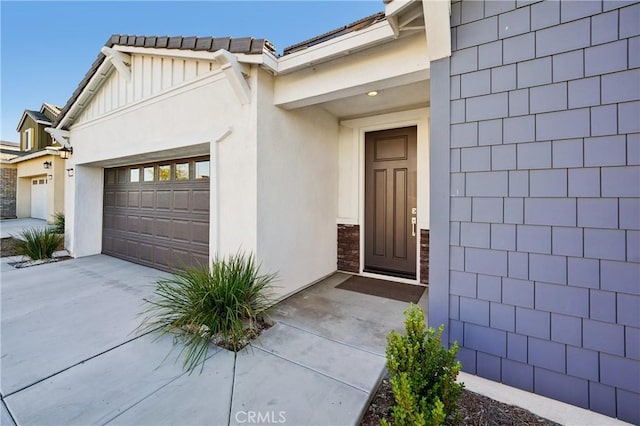 view of exterior entry with driveway and stucco siding