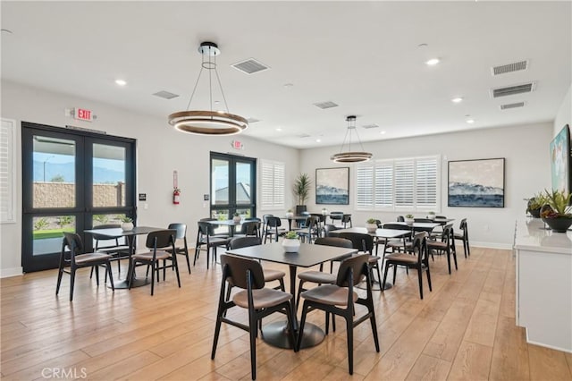 dining area with light wood-type flooring, recessed lighting, visible vents, and french doors