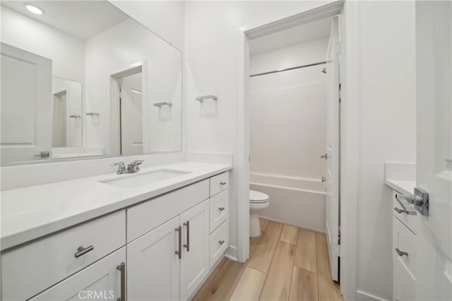 bathroom featuring toilet, bathing tub / shower combination, vanity, and wood finish floors