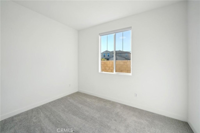 unfurnished room featuring light carpet and baseboards