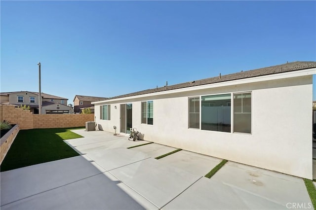 back of house with a fenced backyard, a patio, and stucco siding