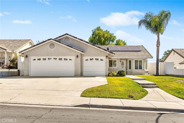 single story home featuring an attached garage, a tile roof, concrete driveway, roof mounted solar panels, and stucco siding