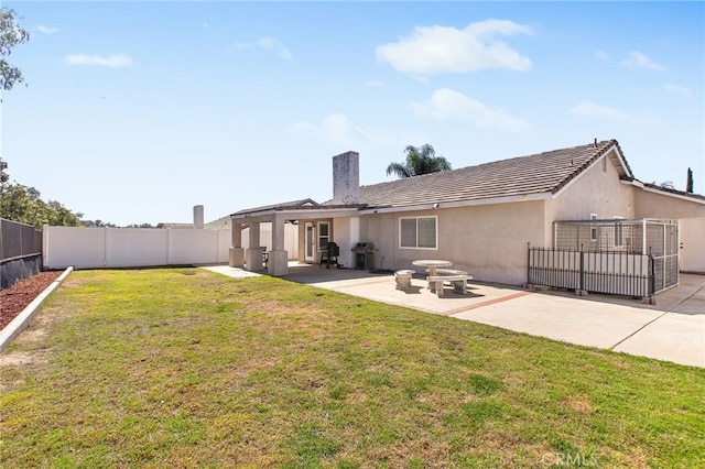 rear view of house featuring a yard, a patio area, a fenced backyard, and stucco siding