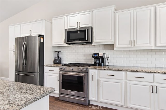 kitchen featuring stainless steel appliances, tasteful backsplash, white cabinetry, and light stone countertops