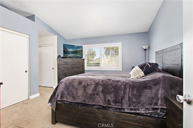 bedroom with lofted ceiling and light colored carpet