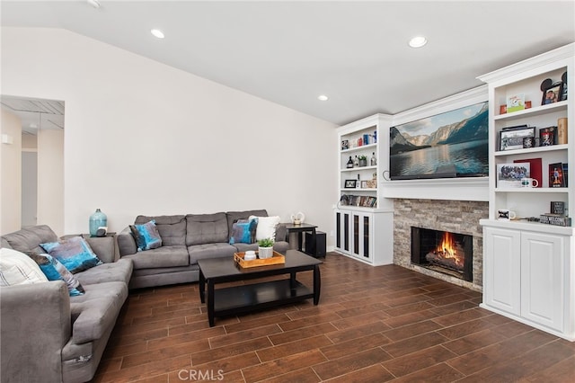 living area featuring lofted ceiling, dark wood-style floors, a fireplace, and recessed lighting