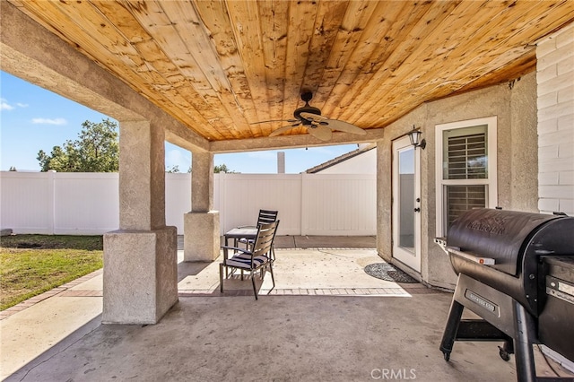 view of patio featuring ceiling fan, area for grilling, and a fenced backyard