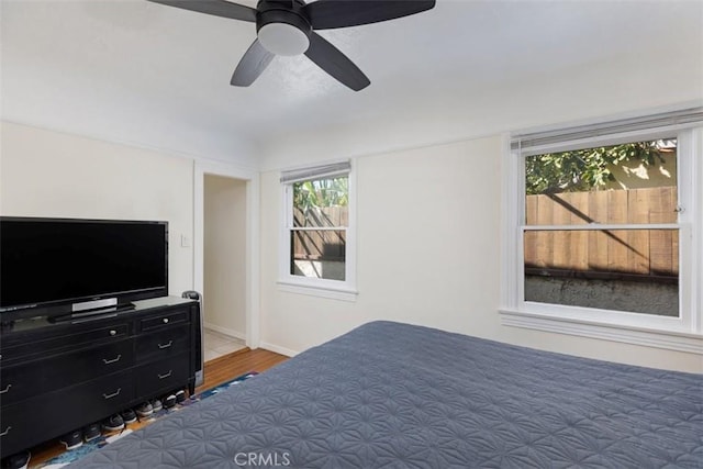 bedroom featuring wood finished floors, a ceiling fan, and baseboards