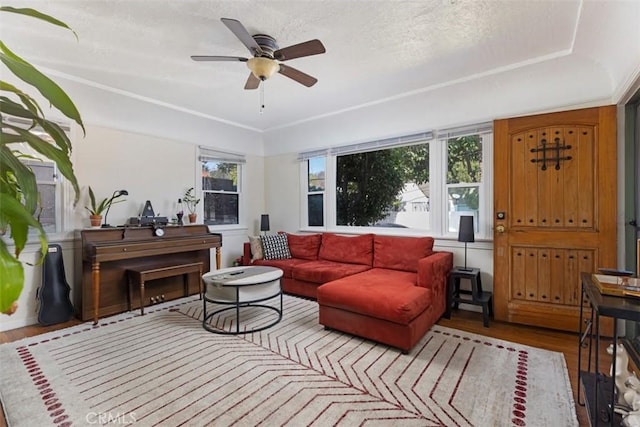 living room featuring light wood-style floors, a textured ceiling, and a ceiling fan