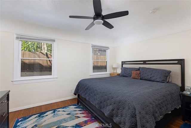 bedroom featuring ceiling fan, dark wood finished floors, and baseboards