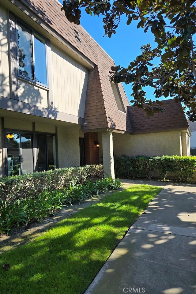 view of home's exterior featuring a lawn and roof with shingles