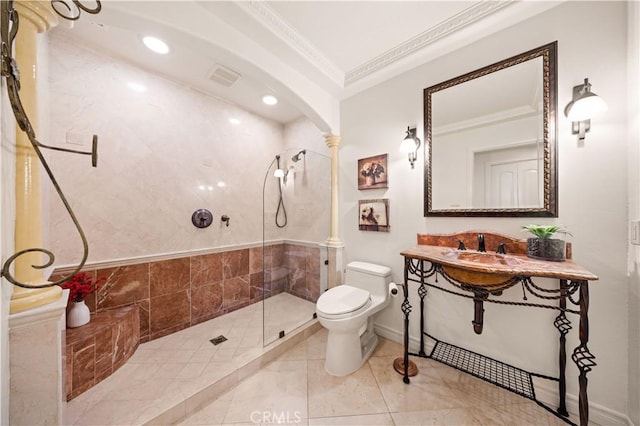 bathroom with toilet, visible vents, a tile shower, decorative columns, and crown molding