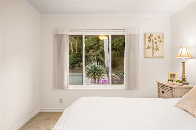 carpeted bedroom with ornamental molding and baseboards