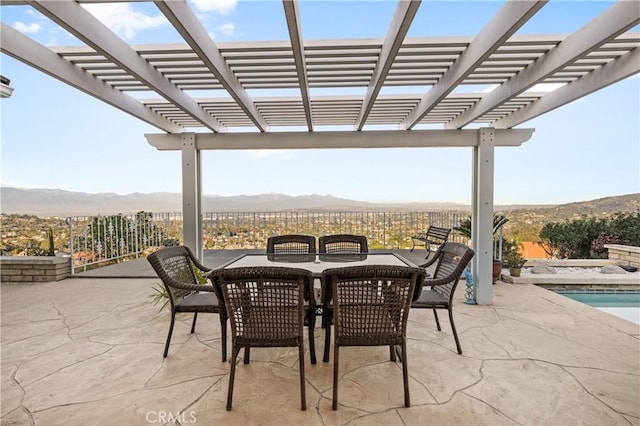 view of patio with outdoor dining space, a mountain view, and a pergola