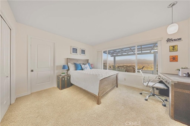 bedroom featuring light carpet and baseboards