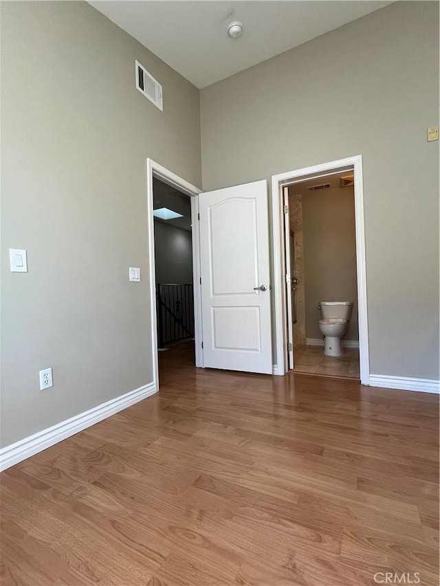 interior space featuring baseboards, visible vents, and light wood-style floors