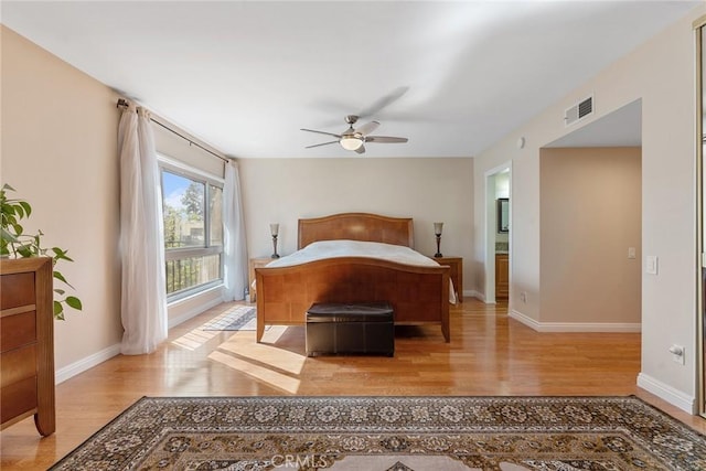 bedroom with light wood-style floors, visible vents, ceiling fan, and baseboards