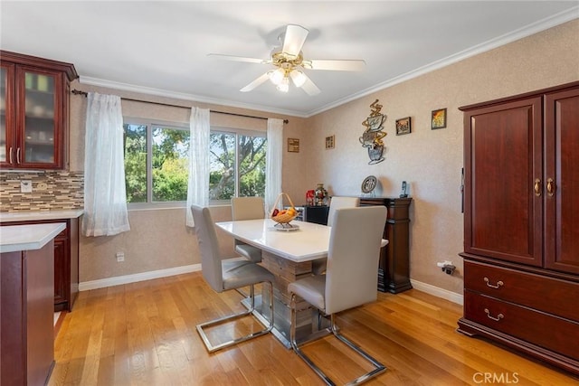 dining area featuring baseboards, ceiling fan, ornamental molding, and light wood-style floors