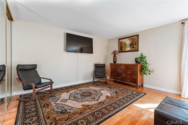 living area with baseboards and wood finished floors