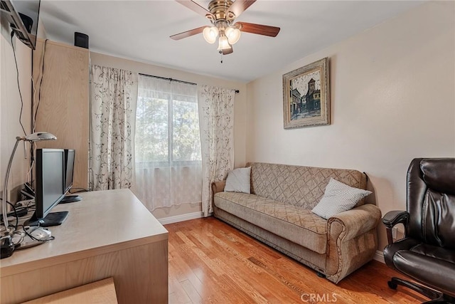 office space featuring ceiling fan, baseboards, and light wood-style floors