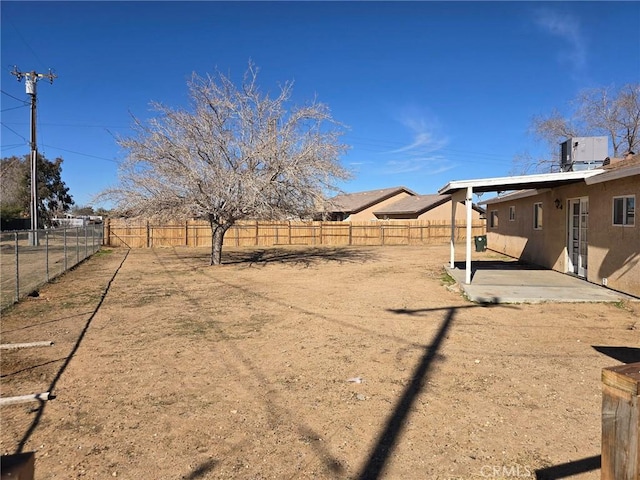 view of yard featuring a patio, central AC unit, and a fenced backyard