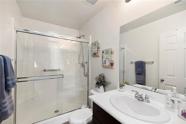 full bathroom featuring toilet, a stall shower, vanity, and visible vents