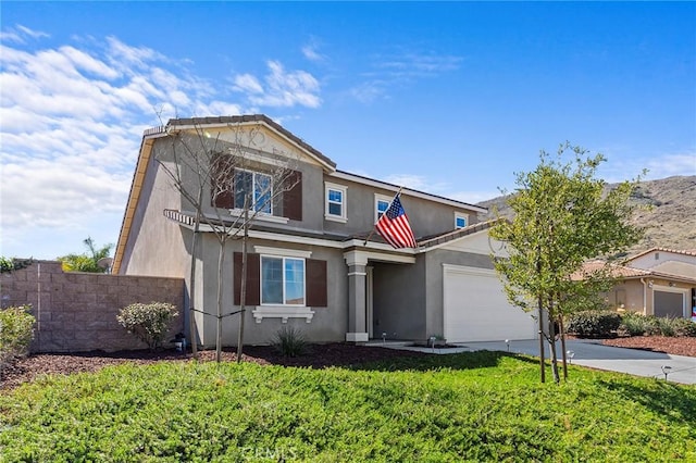 view of front of house with a garage, concrete driveway, a front yard, and stucco siding