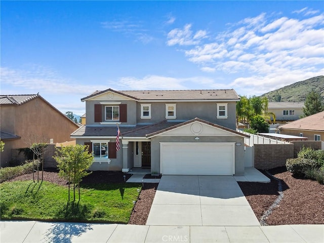 traditional home with stucco siding, fence, a garage, driveway, and a tiled roof