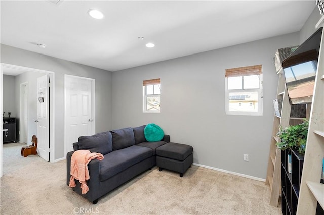 living area featuring a wealth of natural light, light carpet, baseboards, and recessed lighting