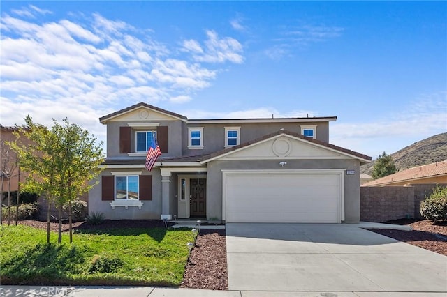 traditional home with an attached garage, driveway, fence, and stucco siding