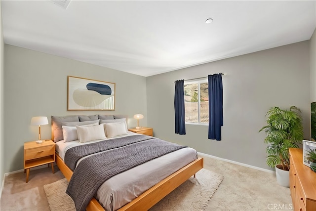 bedroom with light carpet and baseboards