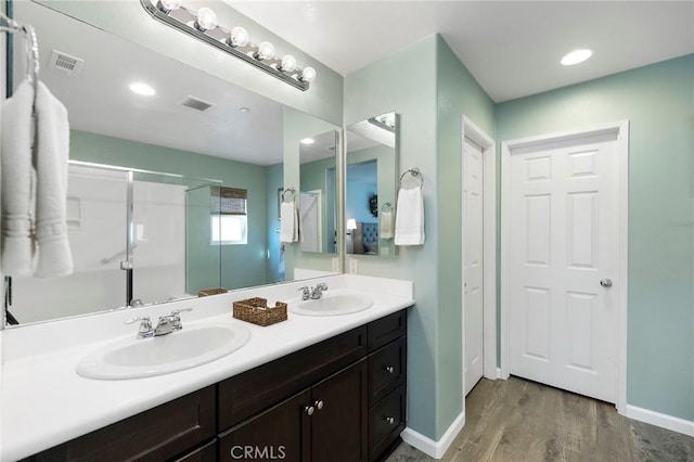 bathroom with visible vents, a sink, and wood finished floors