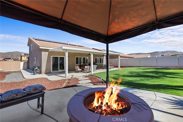 view of patio / terrace featuring an outdoor fire pit, a fenced backyard, and a mountain view