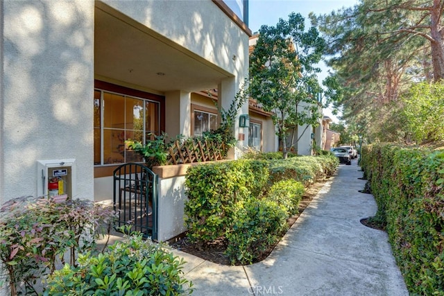 view of property exterior with a gate and stucco siding