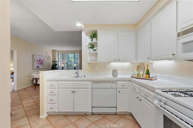 1703 Solvay Aisle Unit 106, Irvine, CA 92606 - kitchen with white appliances, white cabinetry, light tile patterned flooring, tile countertops, and a peninsula
