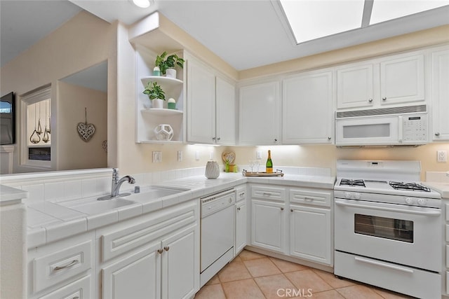 kitchen with tile countertops, open shelves, white cabinets, a sink, and white appliances