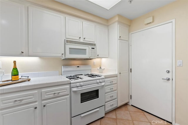 1703 Solvay Aisle Unit 106, Irvine, CA 92606 - kitchen with white appliances, tile countertops, white cabinetry, and light tile patterned floors