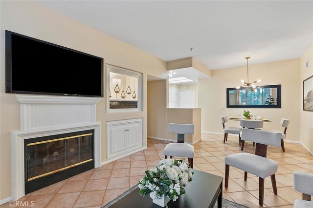1703 Solvay Aisle Unit 106, Irvine, CA 92606 - living room featuring light tile patterned floors, a chandelier, and a glass covered fireplace