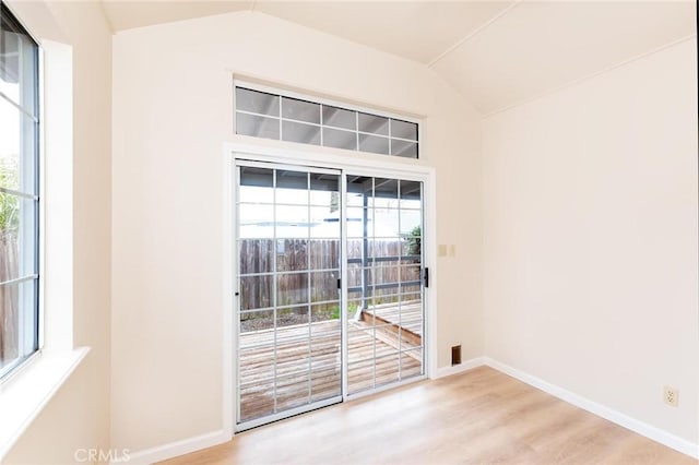 entryway with lofted ceiling, light wood-style flooring, and baseboards